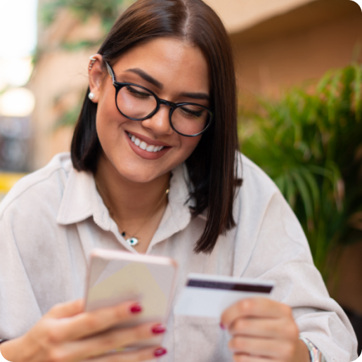 Eine Frau hält ein Smartphone und eine Kreditkarte