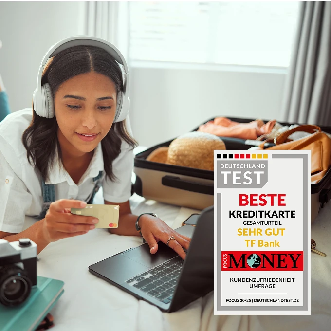 Mädchen liegt auf Bett mit Kopfhörern auf. Vor ihr liegt ein Laptop und sie hat die TF Mastercard Gold in der Hand. Auf dem Bett liegt außerdem bereit ein Koffer und ein Fernglas.