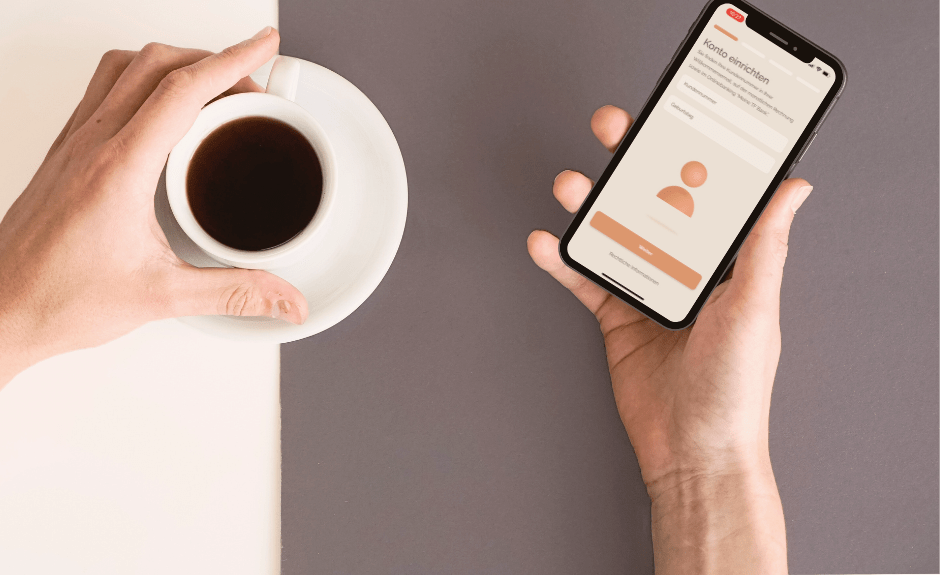 Man sieht einen linken Arm mit einem Kaffee in der Hand und einen rechten Arm mit einem Smartphone in der Hand. Abgebildet ist die TF Bank Mobile App mit dem ersten Schritt zur Kontoeinrichtung.