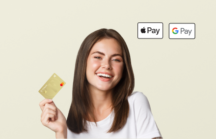 Frau hält goldene TF Mastercard Gold und lächelt zufrieden in die kamera. Apple Pay und Google Pay sind kompatibel
