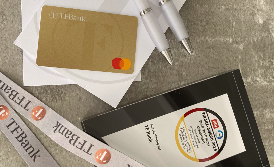 Finanz Award Auszeichnung 2024 der TF Mastercard Gold liegt zusammen mit der Kreditkarte, einem TF Bank Block und Stiften auf einem Tisch.