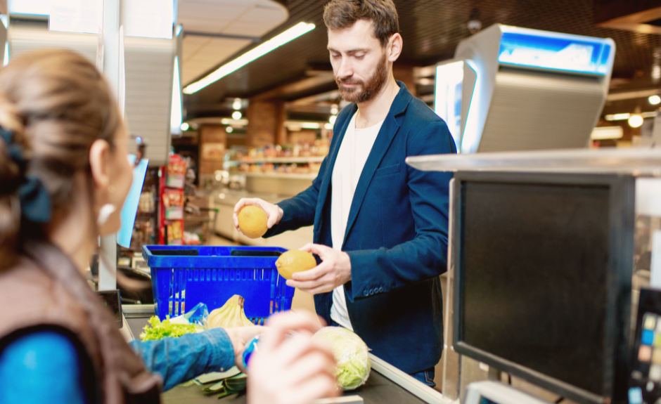 Ein Mann legt Artikel auf das Kassenband im Supermarkt.